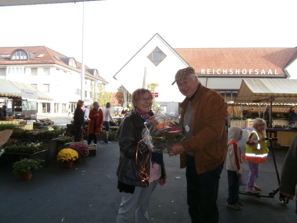 Edith Holzer bekommt Blumenstrauß von Herbert Eisen